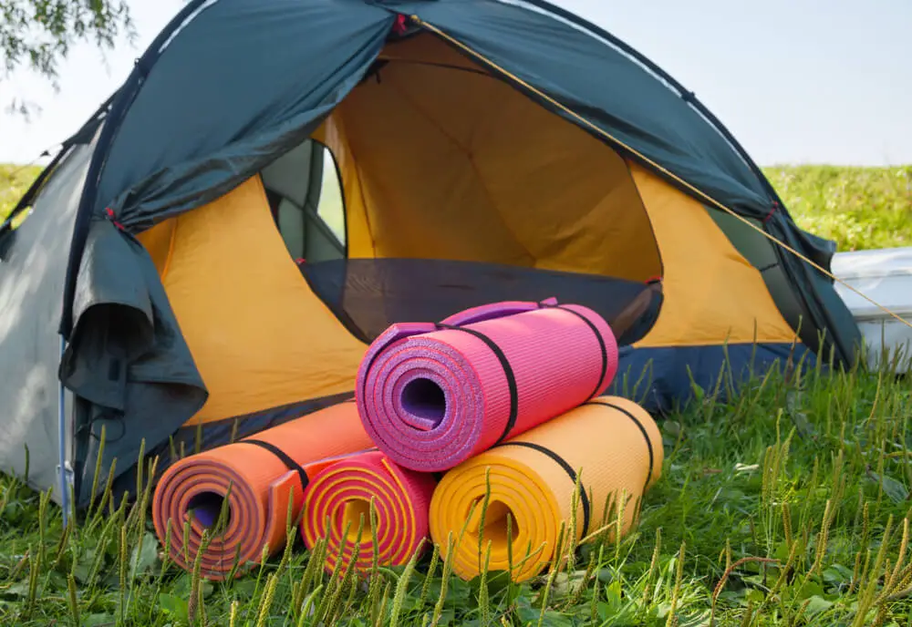 Open tent and rolled sleeping pads 
