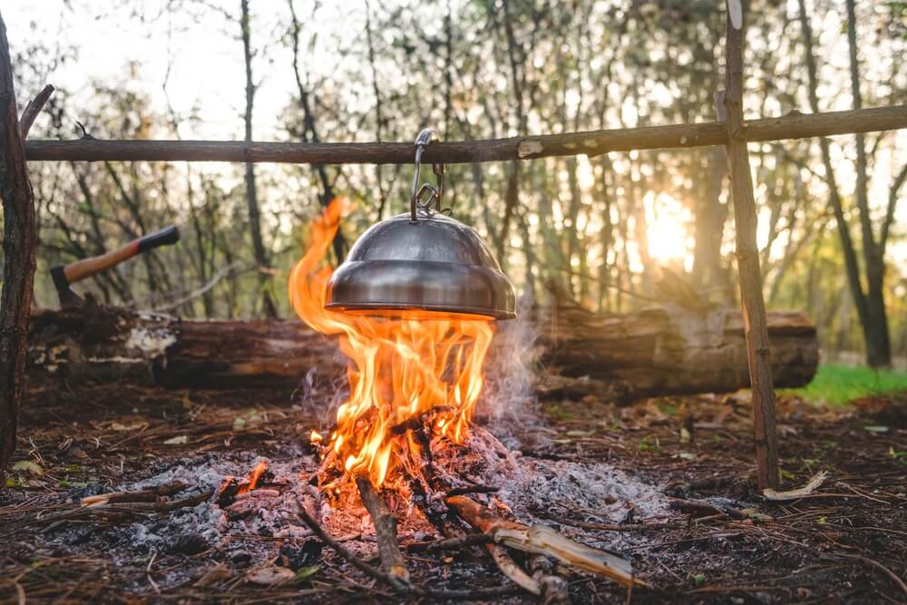 kettle is heated on a campfire